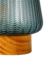 Close-up of blue glass lamp with herringbone pattern on light wooden base, decorative home lighting