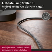 LED-tafellamp Stellan II met grijze stoffen kabel en geïntegreerde snoerschakelaar op houten oppervlak