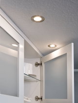 Zwei runde Einbauleuchten mit warmweißem Licht in weißer Küchenumgebung mit offenem Schrank.