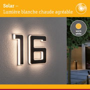 Numéro de maison solaire avec lumière LED blanc chaud sur mur gris pour éclairage extérieur et numéro