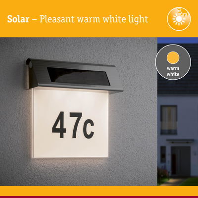 Solar-powered house number light with warm white illumination and stainless steel frame for outdoor use