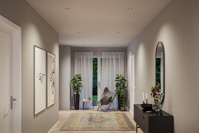 Modern hallway with grey chair, blue and yellow rug, plants, and black sideboard with mirror and flowers.