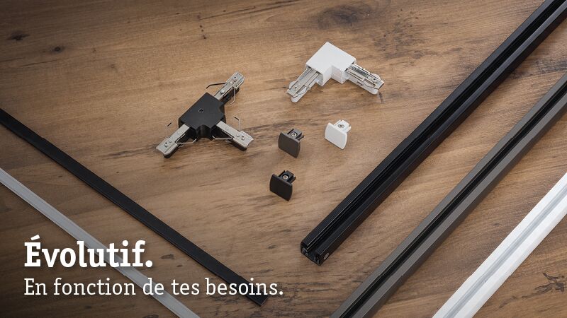 Rails URail noirs et blancs en métal avec connecteurs sur surface en bois pour systèmes d'éclairage modulaires.