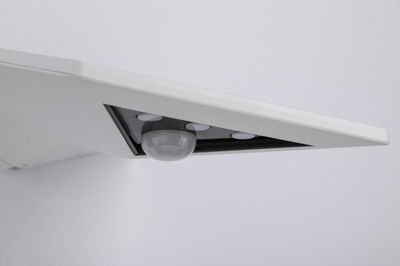 White ceiling light with integrated motion sensor and three detectors for smart room lighting
