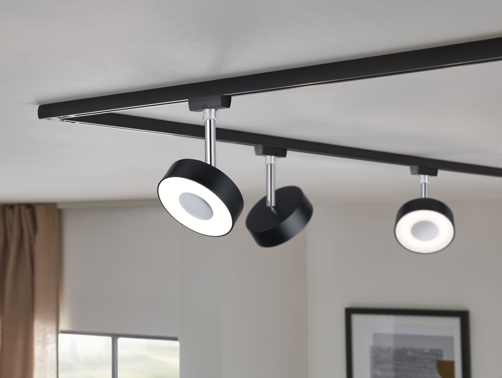Black LED track lighting with three round dimmable metal ceiling spotlights for living spaces.