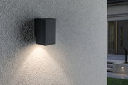 Schwarze rechteckige Außenwandleuchte aus Metall mit warmweißem Licht an grauer Wand