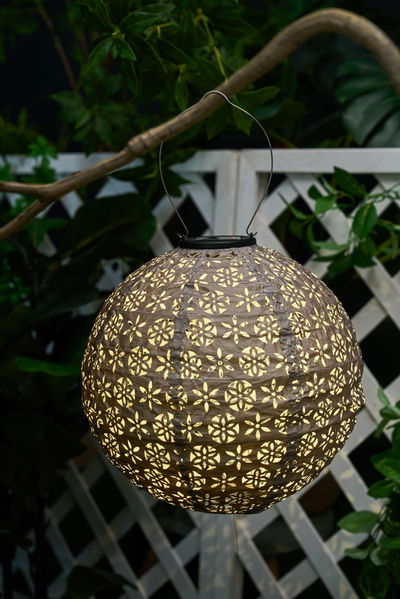 Round brown paper lantern with floral cutouts, decorative outdoor lighting for garden and patio