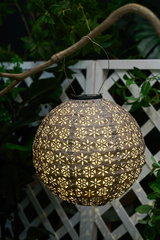 Round brown paper lantern with floral cutouts, decorative outdoor lighting for garden and patio