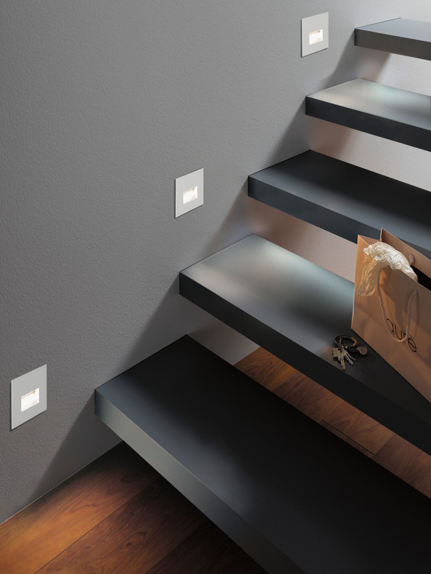 Moderne Treppenbeleuchtung mit weißen LED-Wandeinbauleuchten an grauer Wand und schwarzen Stufen