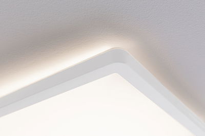 Square white ceiling light with indirect LED glow for modern room lighting.