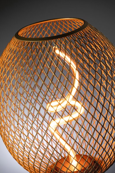 Modern table lamp with spiral LED light and warm glow inside copper-colored metal mesh shade