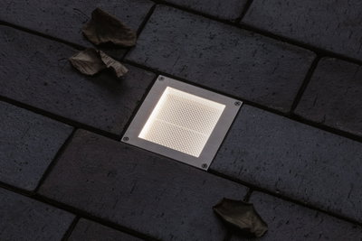 Quadratischer Edelstahl-Einbauleuchte mit warmweißem LED-Licht in dunklem Pflasterboden für Außenbereiche