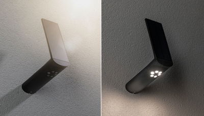 Black LED wall light with solar panel, modern outdoor lighting with motion sensor.
