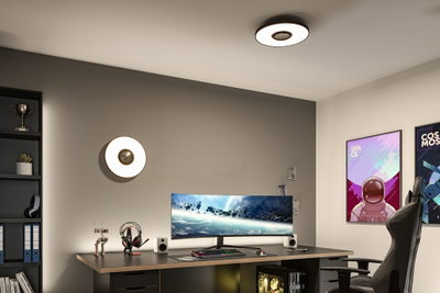 Round white LED ceiling and wall light with black trim, modern room lighting for office or gaming setup.