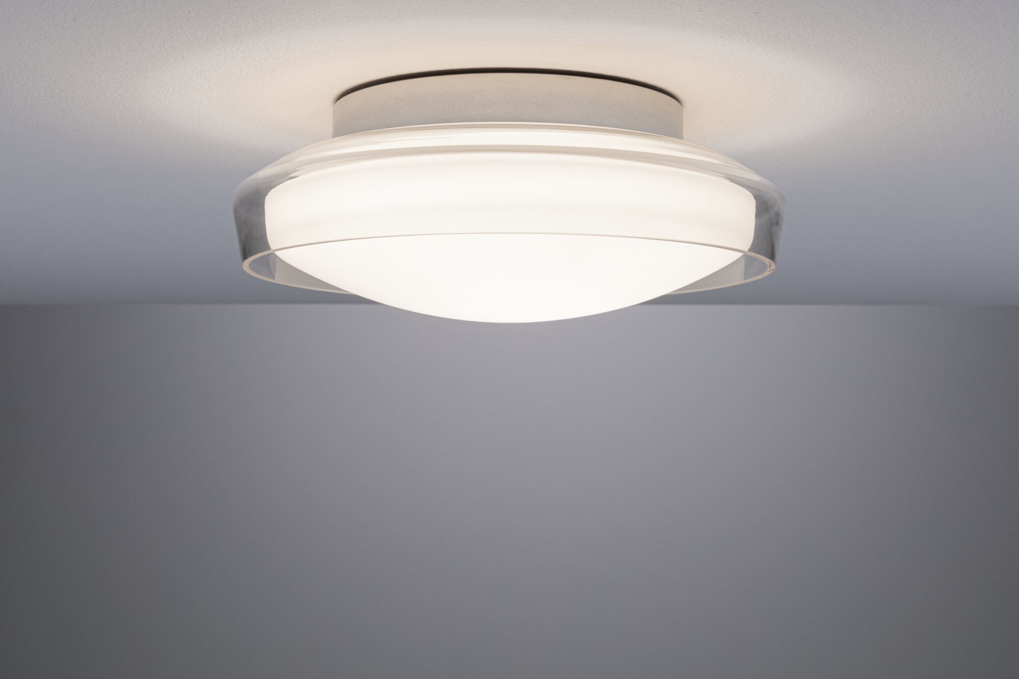 Diskret loftlampe med hvidt glas og transparent kant til moderne belysning.