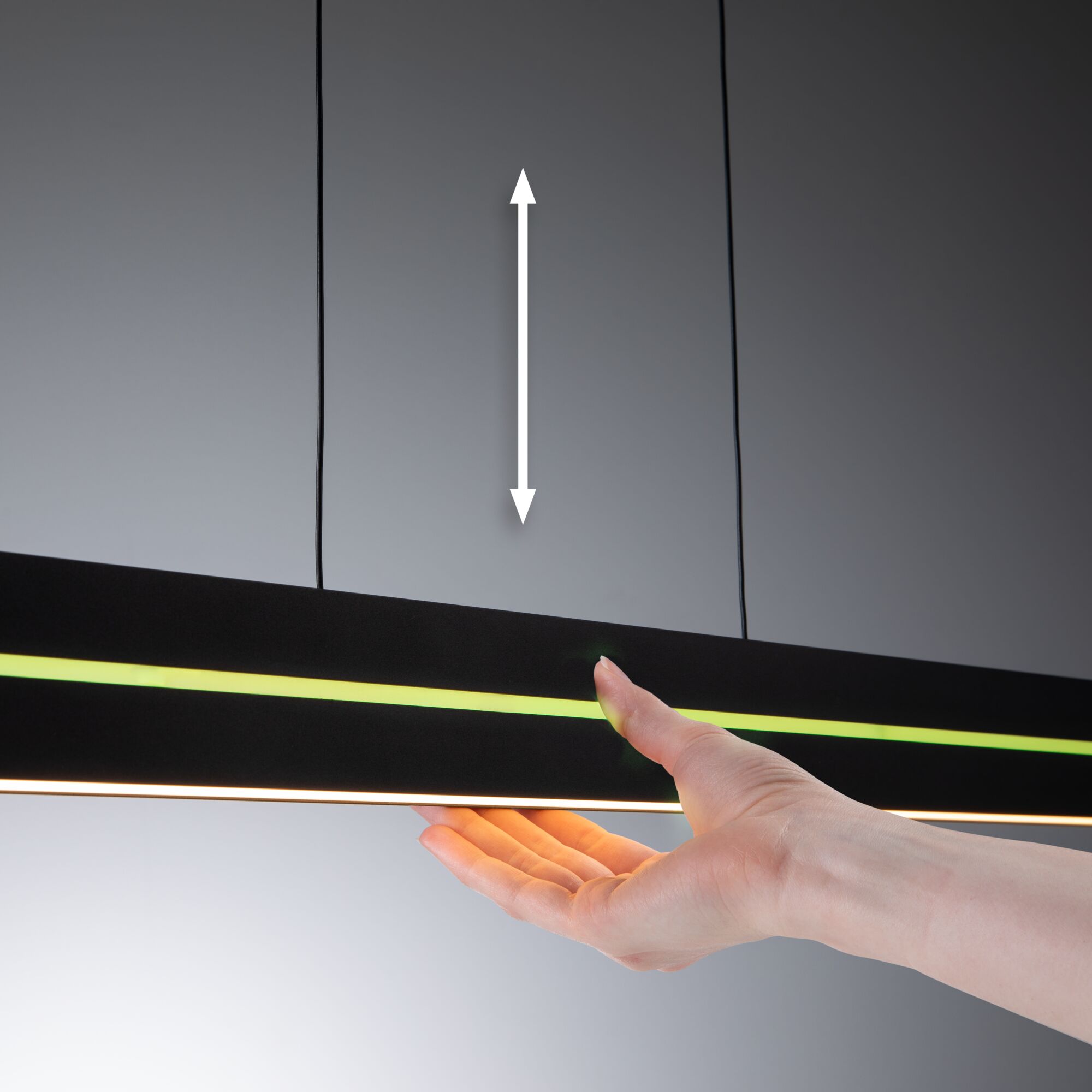 Schwarze LED-Pendelleuchte mit gelbem Lichtstreifen und Hand zur Höhenverstellung, moderne Wohnraumbeleuchtung