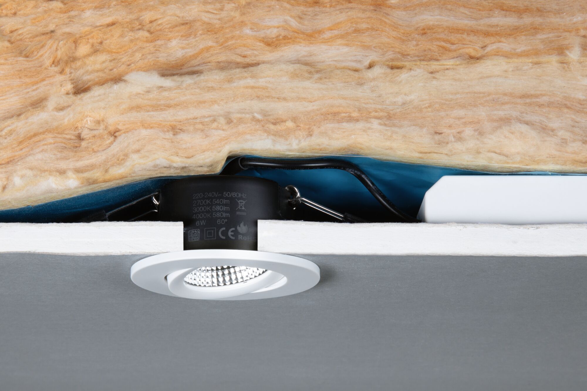 White LED recessed spotlight with black housing in ceiling insulation, energy-efficient lighting solution