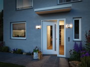 Modern house entrance with white door, grey facade, and illuminated outdoor wall lights for entryway.