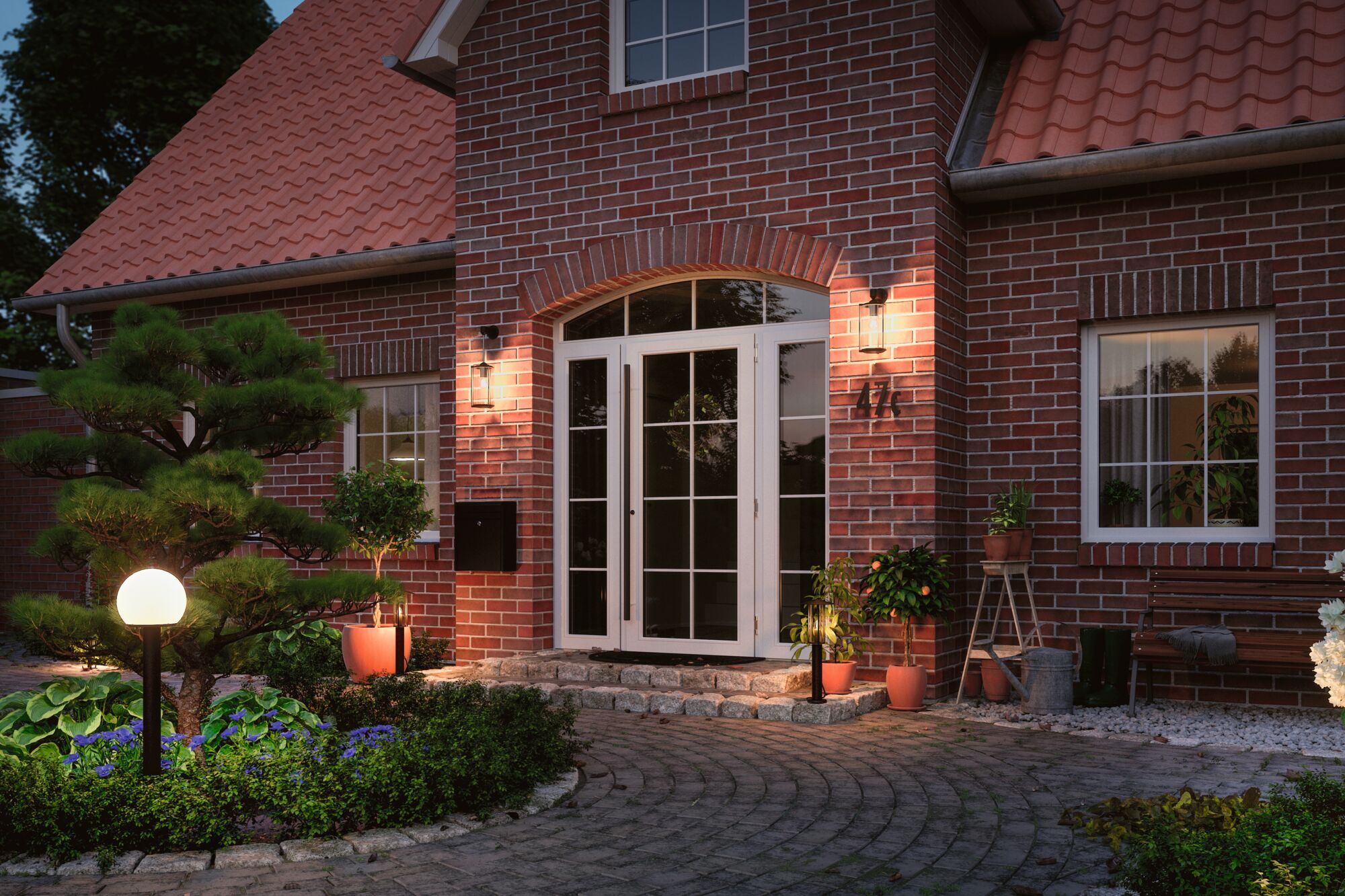 Entrée de maison éclairée avec toit en tuiles rouges, portes blanches et luminaires extérieurs modernes pour jardin.