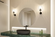Miroir rond de salle de bain avec appliques murales noires et plan de travail en marbre vert avec vasque noire