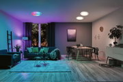 Salon moderne avec plafonniers LED blancs à changement de couleur RGB, canapé et table à manger en bois.