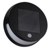 Round black solar light with motion sensor and white plastic light strip for outdoor use