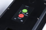 Black electronic device with red on/off button and green mode switch on control panel.