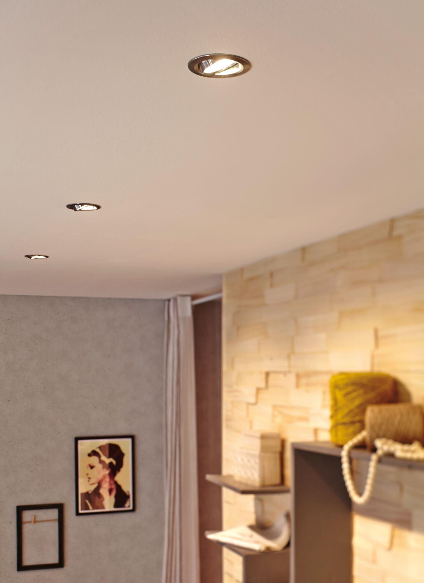 Three recessed LED ceiling spotlights in modern bedroom with wood panel wall and decorative items