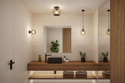 Salle de bain moderne avec meuble en bois, lavabo noir et appliques murales en verre élégantes.