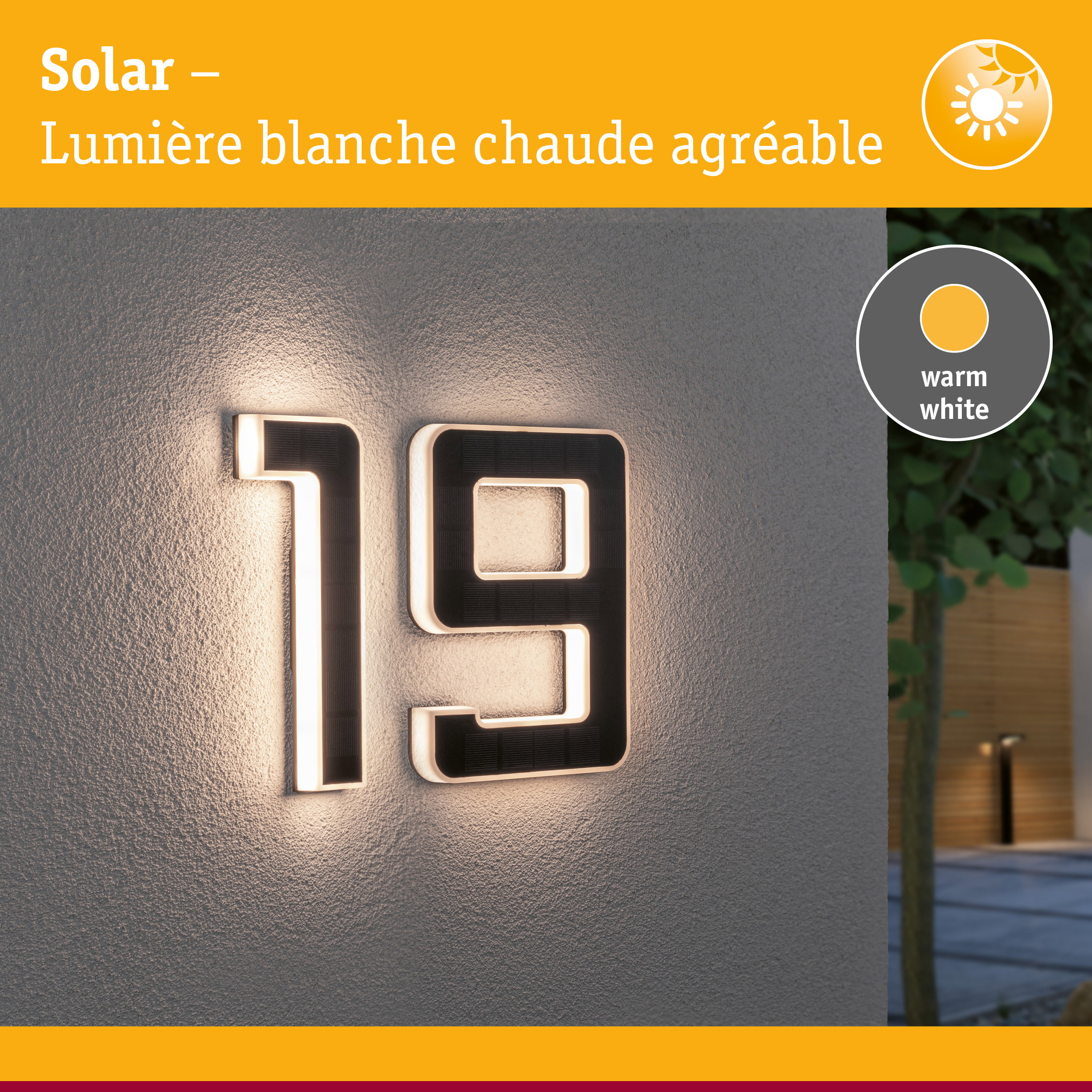 Numéro de maison solaire en matériau noir avec lumière LED blanc chaud sur mur gris