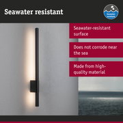 Black LED wall light with seawater-resistant surface mounted on grey wall overlooking the sea