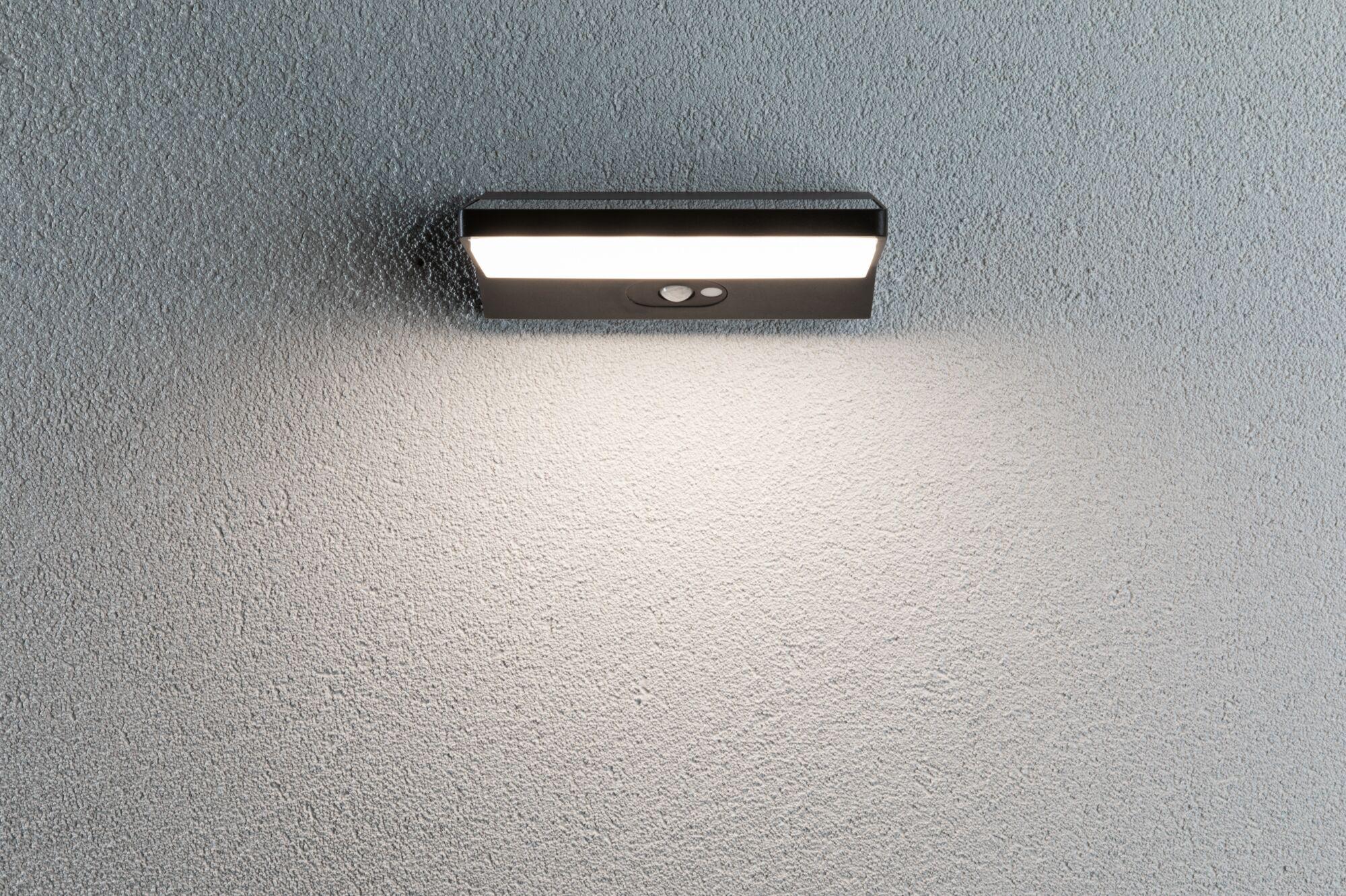 Black LED wall light with motion sensor on grey wall for outdoor lighting and security