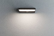 Black LED wall light with motion sensor on grey wall for outdoor lighting and security