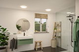 Modern bathroom with round ceiling lights, green vanity cabinet, and black faucet in shower area