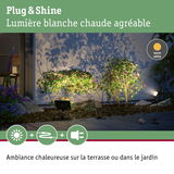 Éclairage LED Plug & Shine blanc chaud illuminant des buissons verts et une terrasse pour une ambiance extérieure chaleureuse
