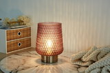 Pink textured glass table lamp with metal base on marble surface for ambient lighting in living spaces