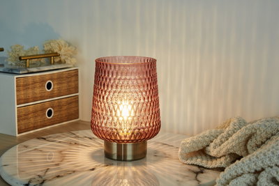 Roze gestructureerde glazen tafellamp met metalen voet op marmeren blad voor sfeerverlichting