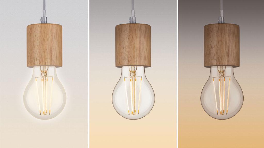 Drei hängende LED-Glühbirnen mit Holzfassung in natürlichem Braun für nachhaltige Beleuchtung.