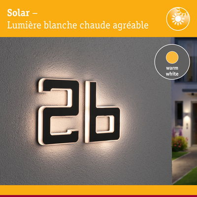Numéro de maison moderne 2b en matériau noir avec lumière LED blanc chaud sur mur gris
