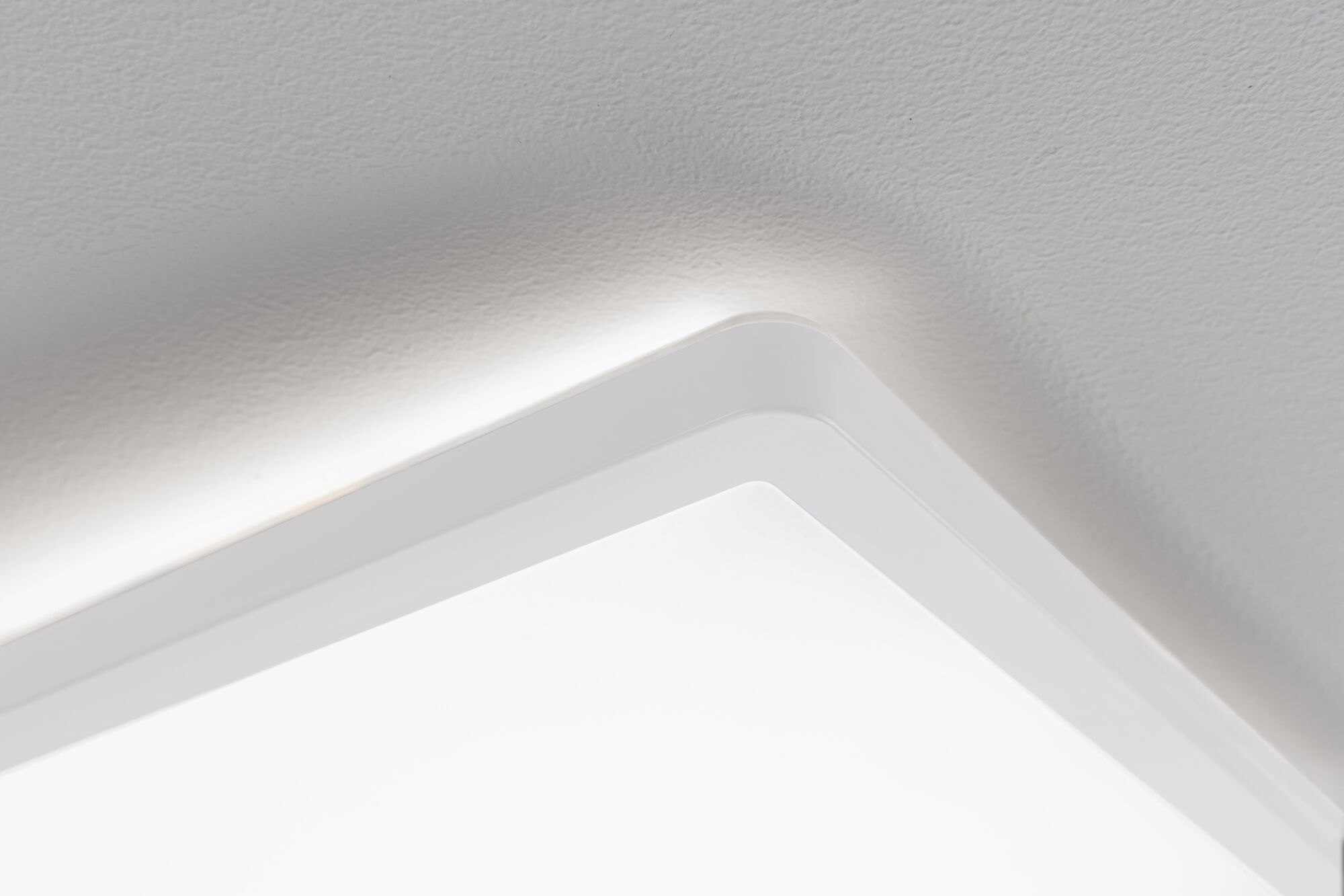 Plafonnier carré blanc aux bords arrondis avec lumière douce pour intérieurs modernes