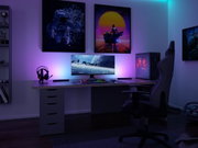 Configuration de jeu moderne avec éclairage RGB, tour PC, écran et chaise ergonomique dans une pièce sombre