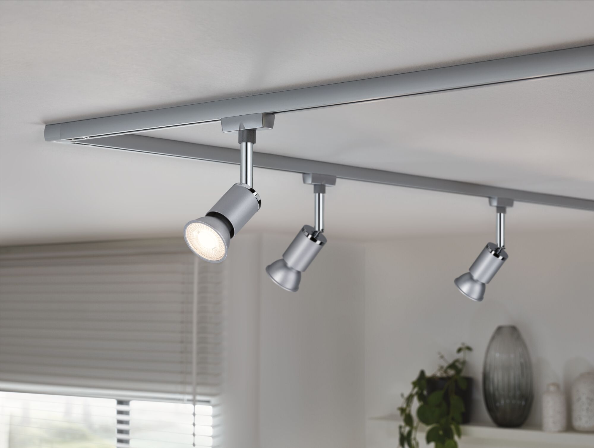 Tre sølvfarvede LED-spotlights på skinnesystem til moderne loftsbelysning.