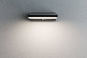 Black LED wall light with motion sensor on grey wall, energy-saving outdoor lighting