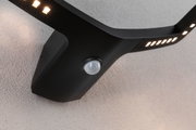 Black LED wall light with motion sensor and warm white LEDs for outdoor use.