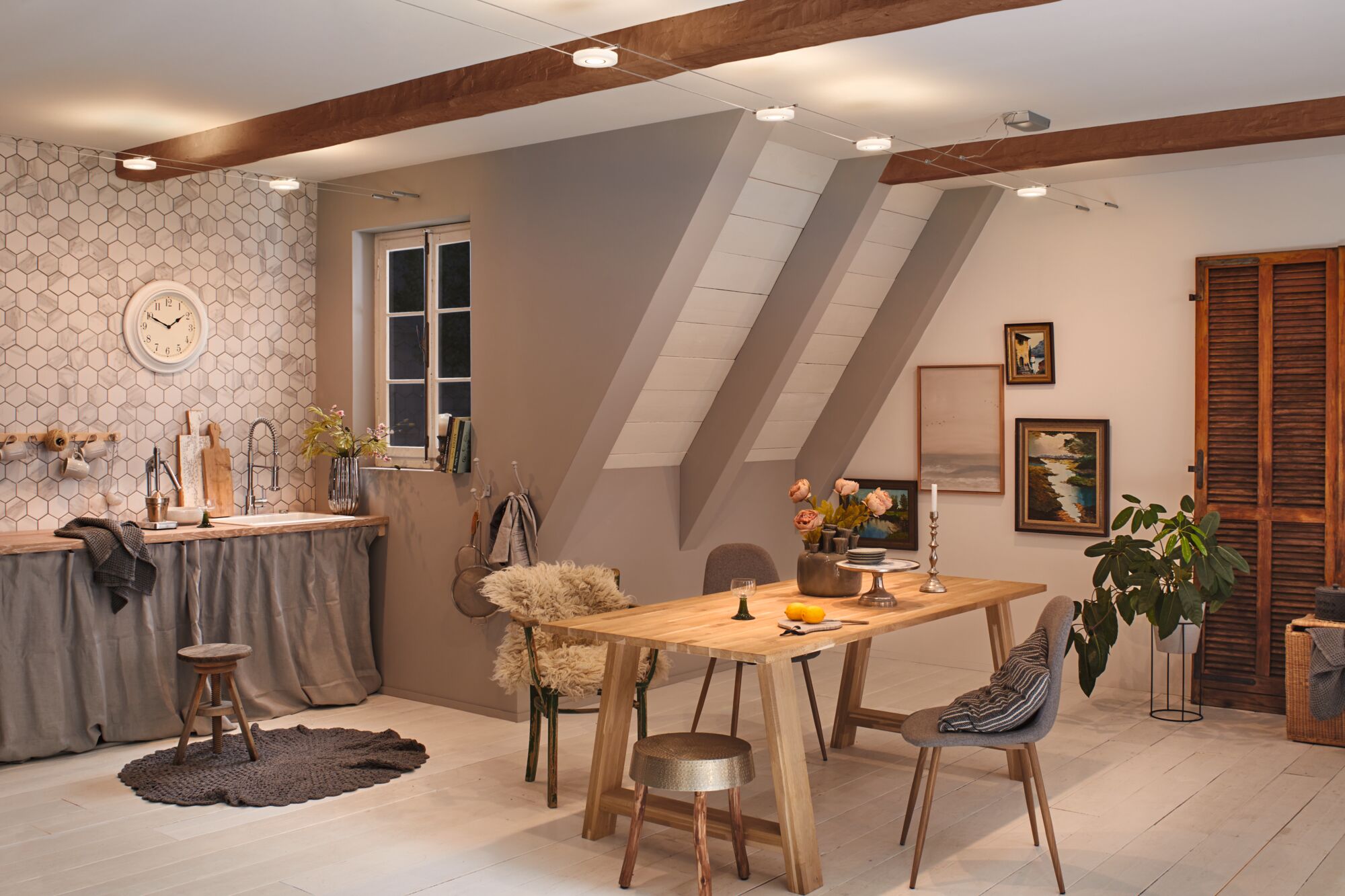 Moderne loftkøkken med træspisebord, grå stole og varm hvid LED-kabelbelysning