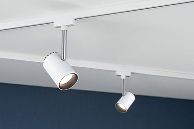 Two white metal LED spotlights on track system mounted on white ceiling for modern lighting