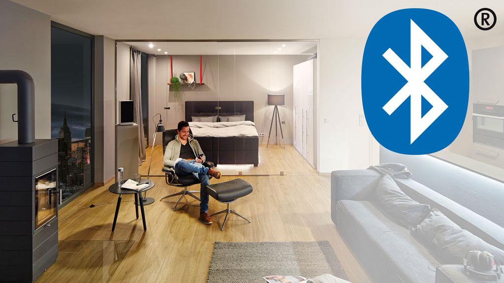 Espace de vie moderne avec sol en bois, fauteuil confortable et icône Bluetooth pour domotique.