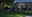 Modern black metal LED outdoor light illuminating garden path near terrace seating area