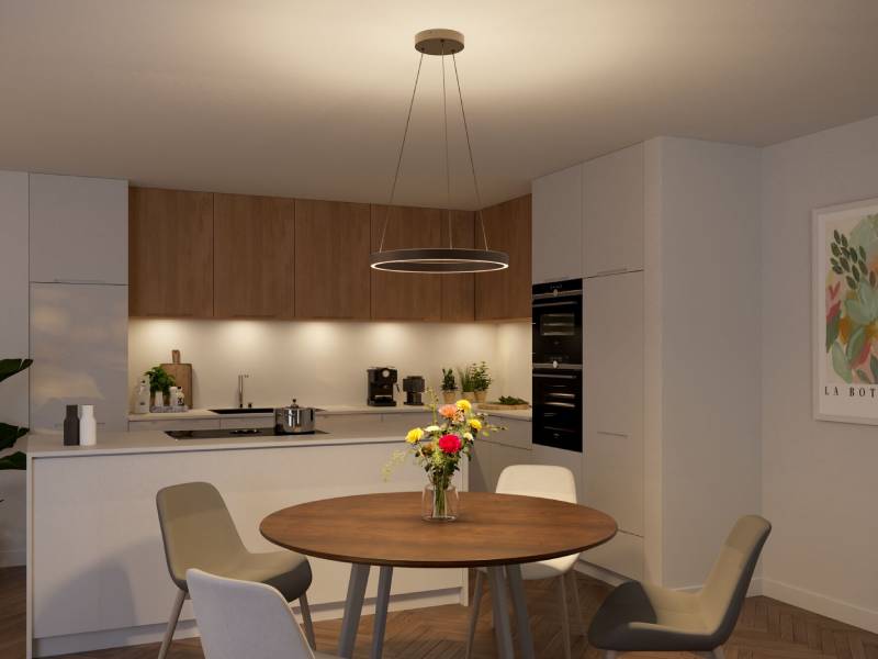 Cuisine moderne avec meubles en bois, plan de travail blanc, table ronde en bois avec fleurs, suspension LED.