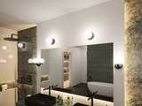 Salle de bain moderne avec robinetterie noire, lavabo noir et appliques murales rondes blanches et noires.